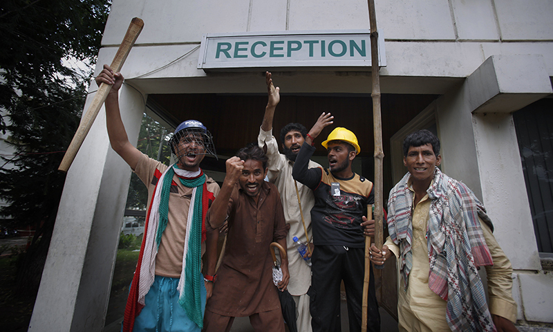 Protesters hold sticks and chant slogans after intruding the state television building in Islamabad, Sept. 1, 2014. —AP photo