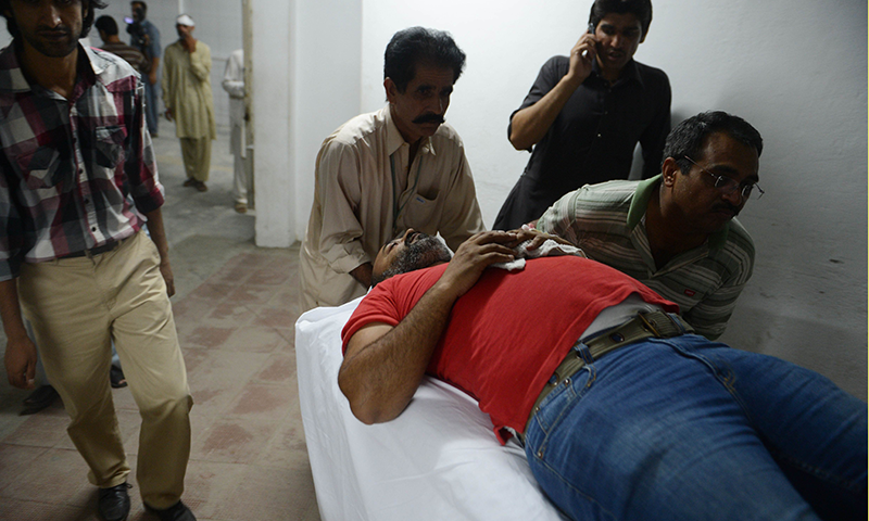 Paramedics move an injured journalist at a hospital after clashes in Islamabad. Photo by AFP