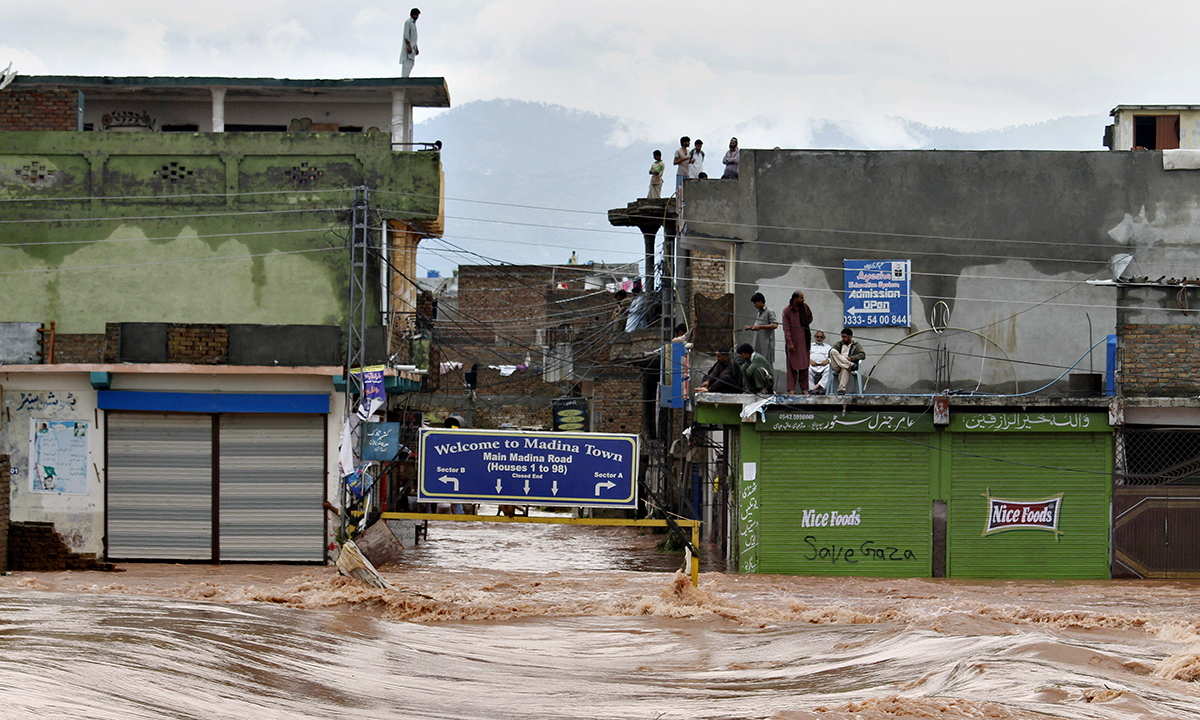 People stand on the rooftop of their flooded houses caused by heavy rains on the outskirts of Islamabad on Friday, Sept. 5, 2014.—AP