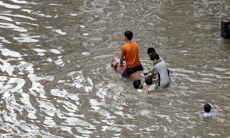  Youngsters crossing the flooded Lakshami Chowk on LPG cylinder after heavy rain. — Photo by INP 