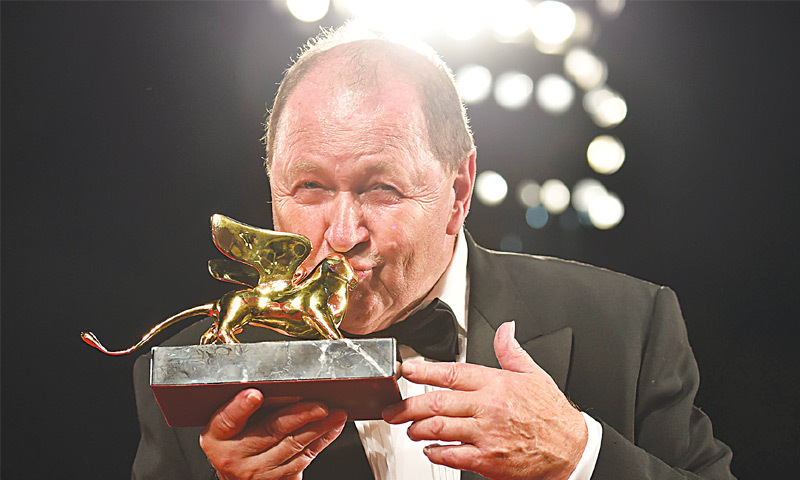 Swedish director Roy Andersson kisses the Golden Lion for Best Film he received for his movie  “A Pigeon sat on a branch reflecting on existence” during the awards ceremony on Saturday.—AFP