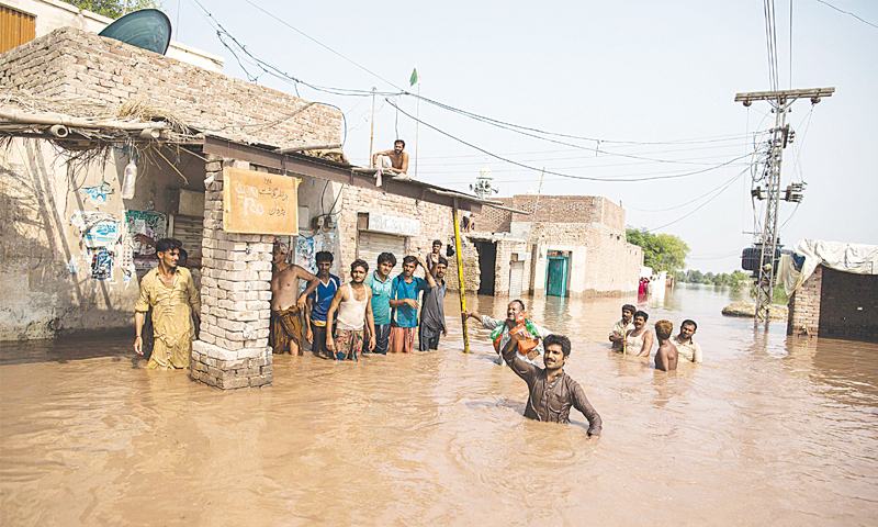 Flood victims wait to be evacuated by boat following heavy rain. — Photo by Reuters