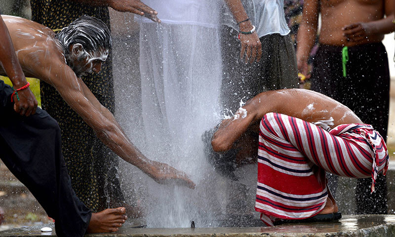 Supporters of Tahirul Qadri and Imran Khan bathe as they camp in front of the Parliament building in Islamabad on September 24, 2014. – AFP Photo