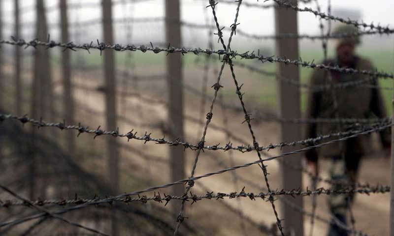 File photo shows an Indian soldier walking by a barbed wire fence across the Line of Control.— File photo