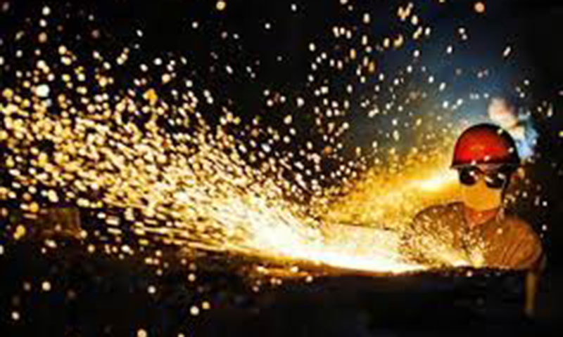 A worker wearing protective glasses welds steel products at a heavy equipment manufacturing factory. &mdash; Reuters/File