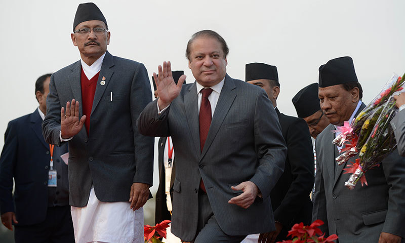 Prime Minister Muhammad Nawaz Sharif (C) waves on his arrival at Tribhuvan International Airport to attend the 18th South Asian Association for Regional Cooperation (SAARC) summit in Kathmandu on November 25, 2014. - AFP photo