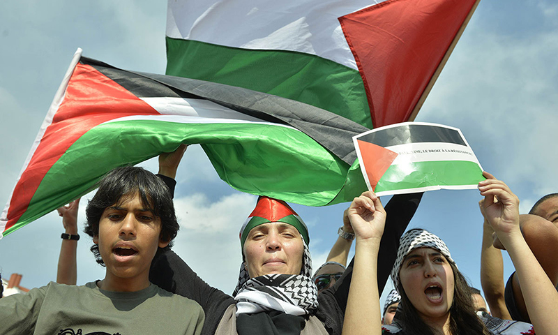 People shout slogans and hold Palestinian flags during a demonstration in Lyon, central eastern France to show their support for the Palestinian people. — AFP/File