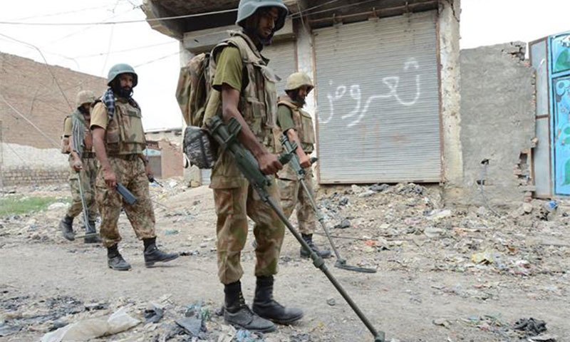 A security person scans a blast site in one of the tribal areas in the country.  — Courtesy: ISPR