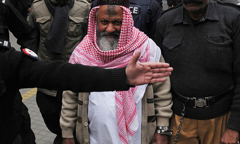 This photograph taken on December 22, 2014 shows police escorting the head of banned Lashkar-i-Jhangvi (LJ) Malik Ishaq as he arrives at the high court in Lahore. - AFP