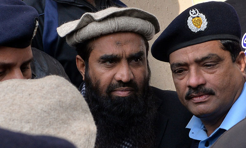 Security personnel escort Zakiur Rehman Lakhvi (C), alleged mastermind of the 2008 Mumbai attacks, as he leaves the court in Islamabad on December 30, 2014. &mdash; AFP