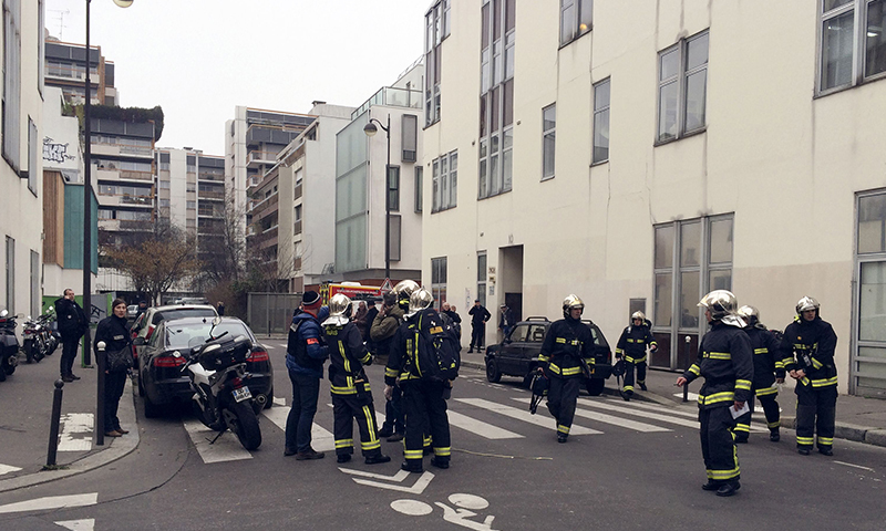 Police officers and firefighters gather in front of the offices of the French satirical newspaper Charlie Hebdo in Paris. - AFP Photo