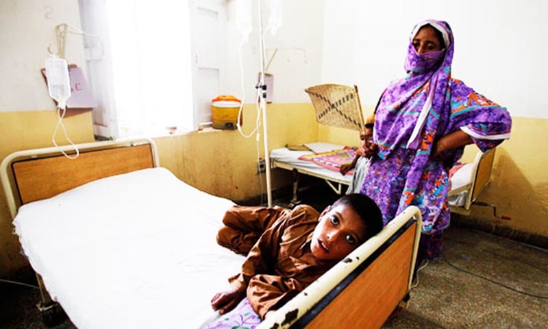 A child suffering from diarrhoea, lies on a bed next to his mother at a government hospital in Sukkur.—Reuters/File