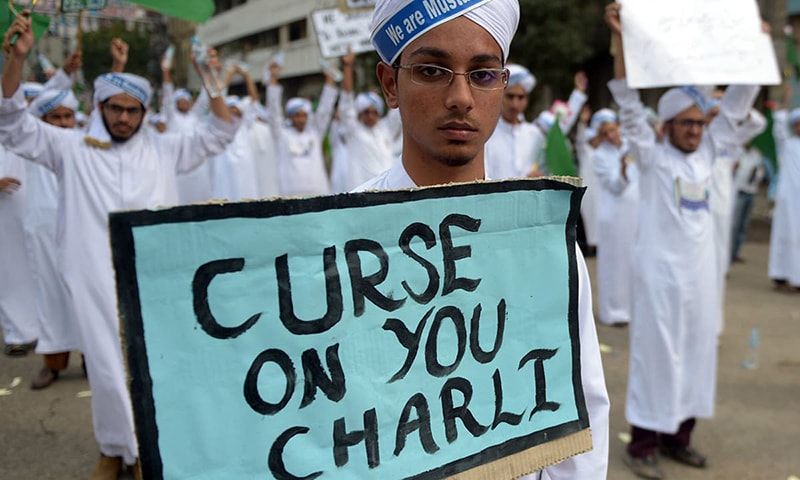 In this photo, a protesting student carry a placard with text "Curse on you Charlie" during a rally in Karachi. — AFP/File