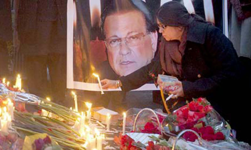 A woman lights a candle next to an image of the governor of Punjab Salman Taseer.&mdash;Reuters/File