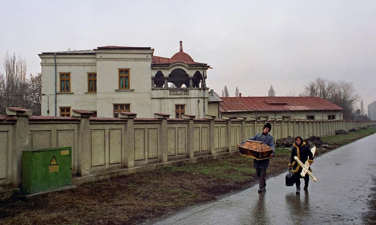 Romanian parents carry a small casket and cross as they arrive at a Bucharest hospital to collect the body of their dead baby&mdash;Reuters