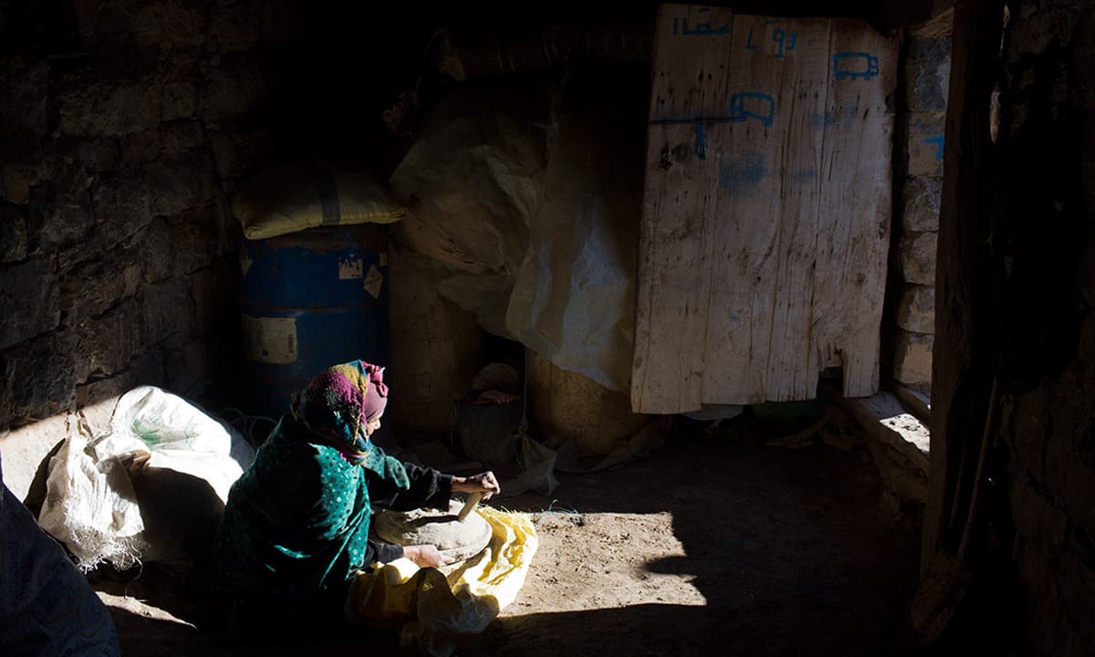 A woman prepares bread in her doorway in Ait Sghir village.