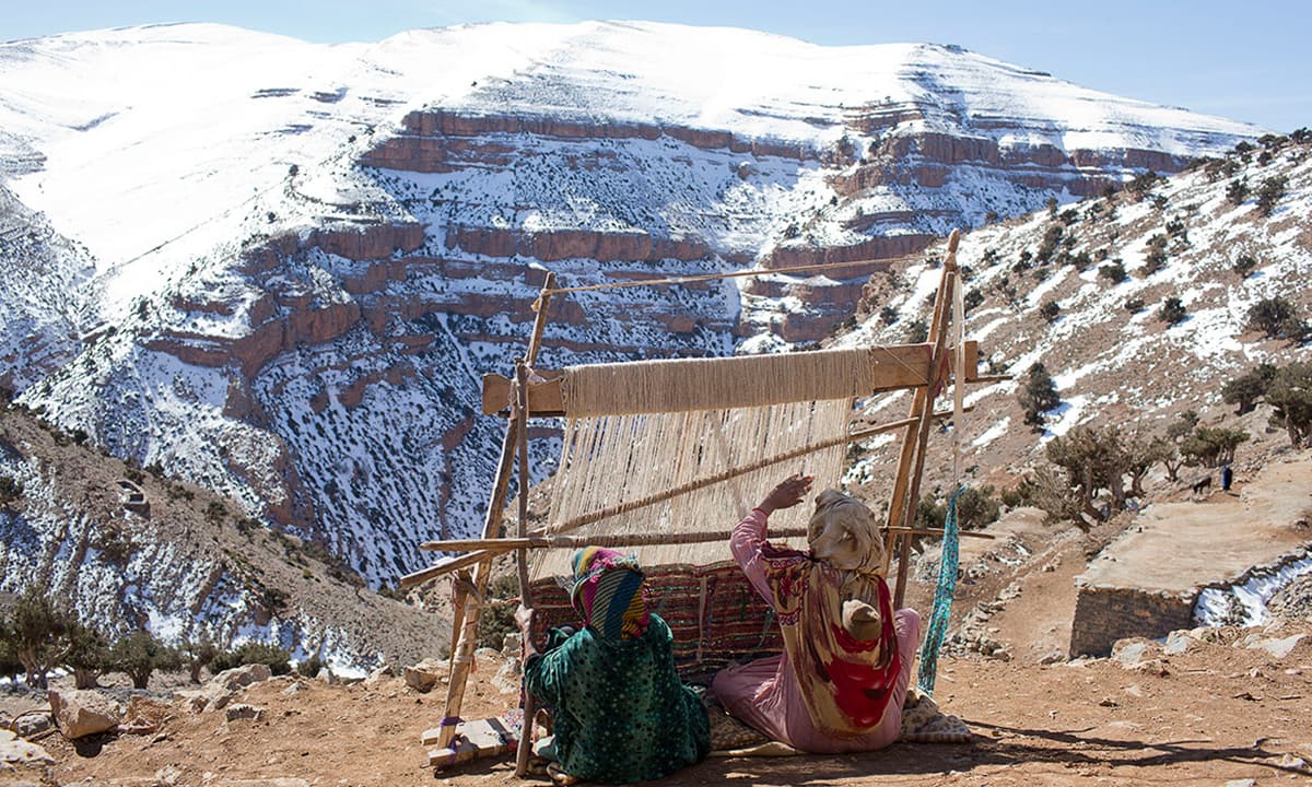 Berber women weave traditional carpets in the village of Ait Sghir in the High Atlas region of Morocco.