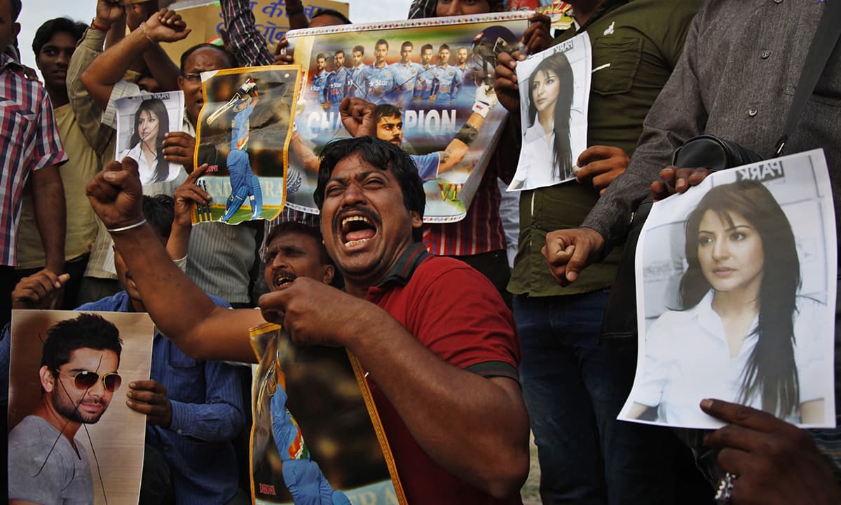 Indian fans shout slogans with posters of  Indian cricket player Virat Kohli, left and his girlfriend and Bollywood actor Anushka Sharma, right, as they react to India’s defeat in the ICC cricket world cup semi-final match against Australia, in Ahmadabad, India.-AP