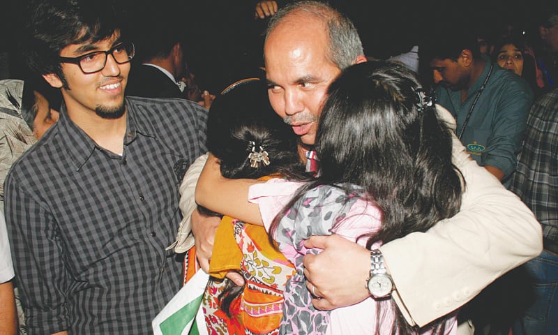 KARACHI: A man who arrived here on Sunday night from Yemen by a special PIA flight hugs his daughters at the airport.—White Star