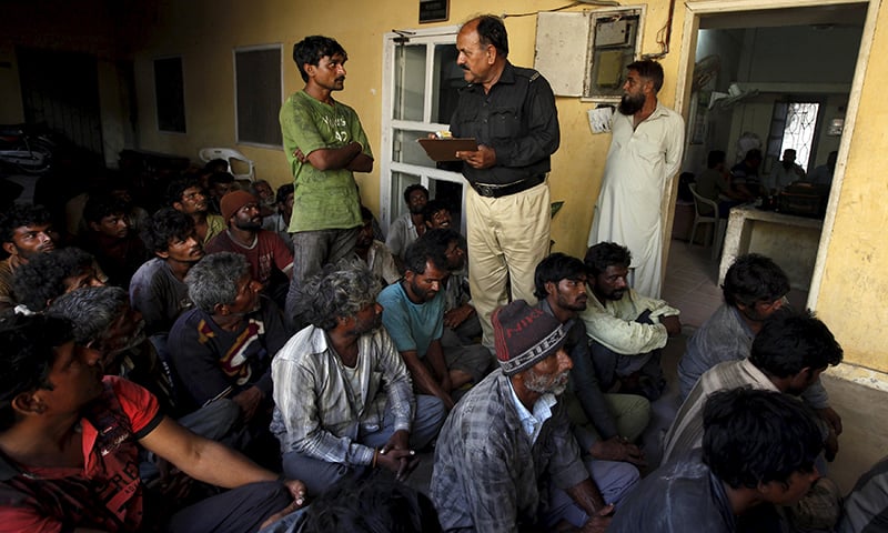 A policeman inquires details from a fisherman from India at a police station in Karachi. &mdash;Reuters