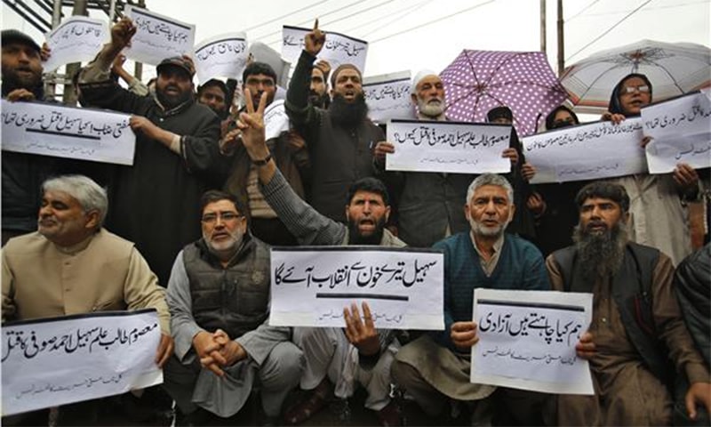 Hurriyat supporters on Sunday shout slogans and hold placards in Urdu protesting against the killing of a teenage boy during weekend protests in Srinagar ─ AP