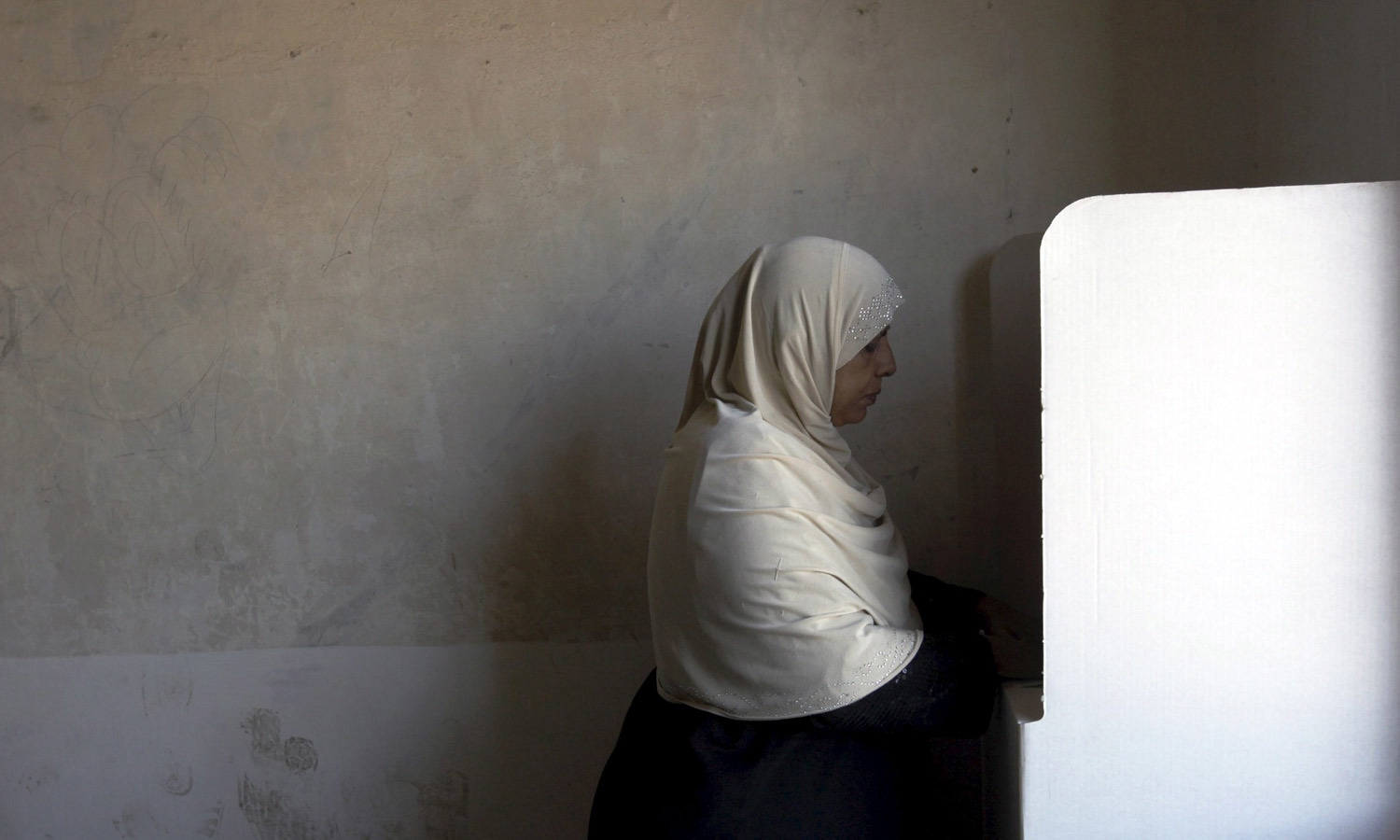 A woman fills in her ballot at a polling station during the by-election. &mdash; Reuters