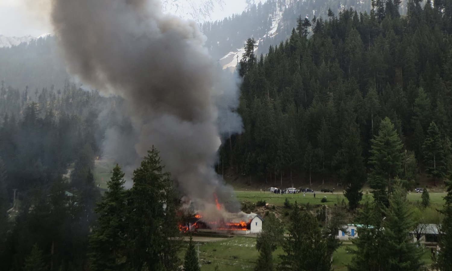 Flame and smoke rises from the site where the helicopter crashed on a school building in Naltar. The crash resulted in killing seven people including the Norwegian and Philippine envoys.  &mdash; AFP