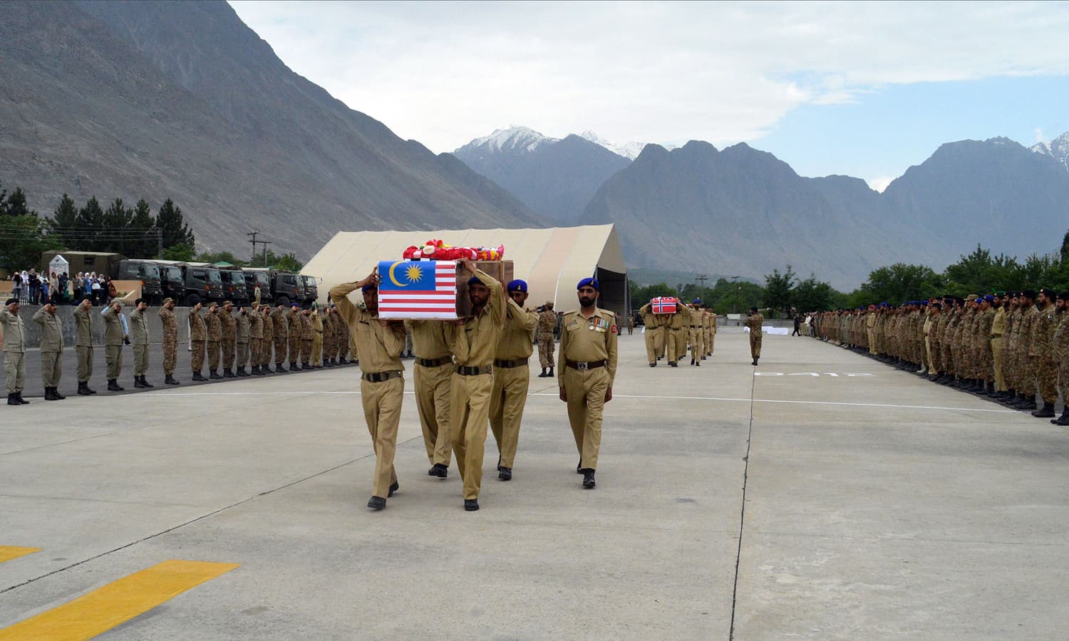 Soldiers carry the coffins of the wife of the Malaysian ambassador and the Norwegian ambassador Leif H. Larsen during a ceremony in Gilgit. &mdash; AFP