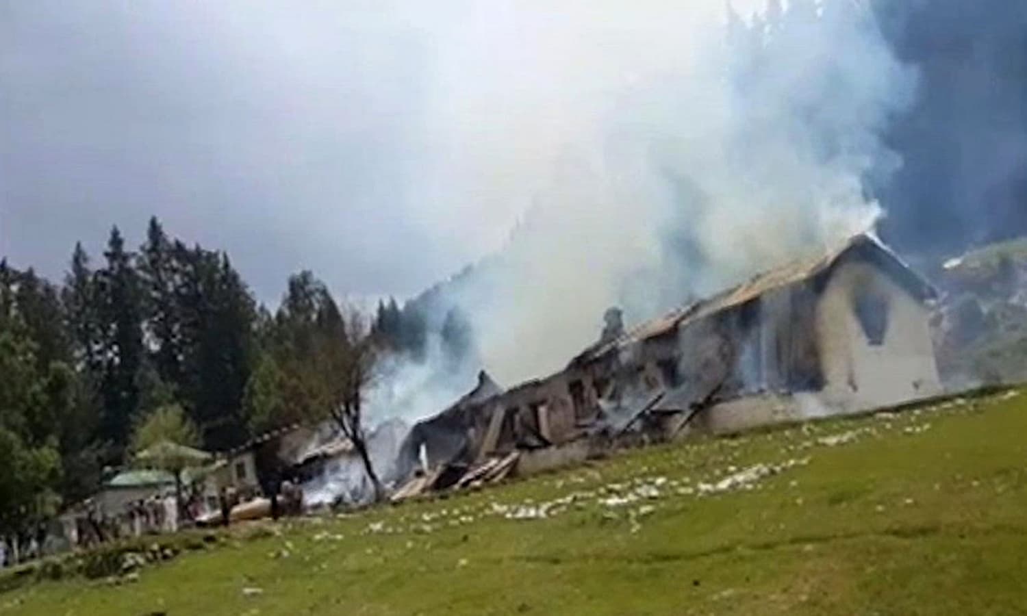 This still image taken from video shows smoke rising from an empty burning building, belonging to a school, where the helicopter crashed in Nalter Valley. &mdash; AP
