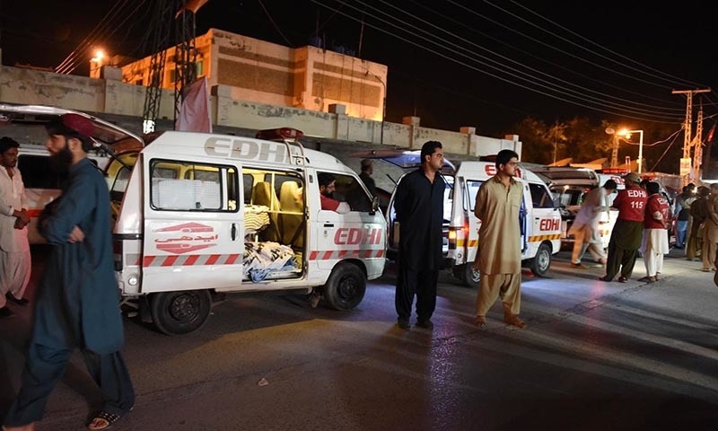 Residents gather around an ambulance carrying dead bodies of killed bus passengers outside the hospital in Quetta. — AFP Photo