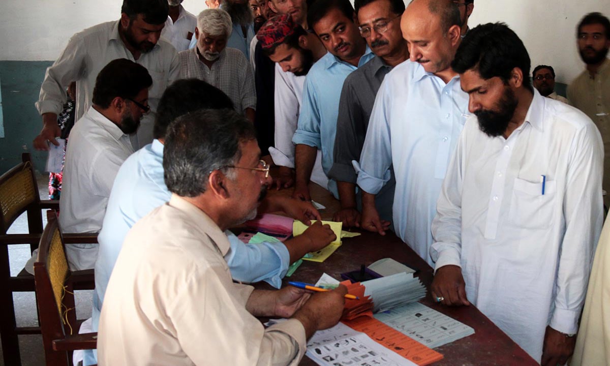 People searching their names in the voters’ list during local government elections in Peshawar. -Online