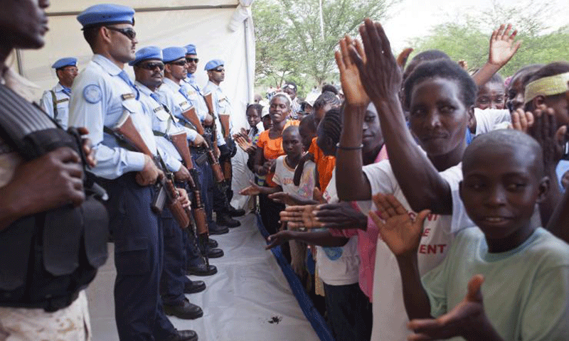 United Nations peacekeepers stand guard as Haitians gather to see U.N. Secretary-General Ban Ki-moon during his visit to the village of Los Palmas July 14, 2014. &mdash; Reuters
