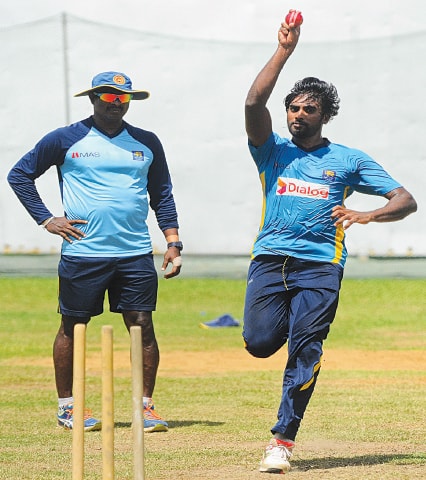 Colombo: Sri Lankan pacer Nuwan Pradeep delivers a ball as bowling coach Champaka Ramanayake looks on during a practice session at the R. Premadasa Stadium on Wednesday.&mdash;AFP