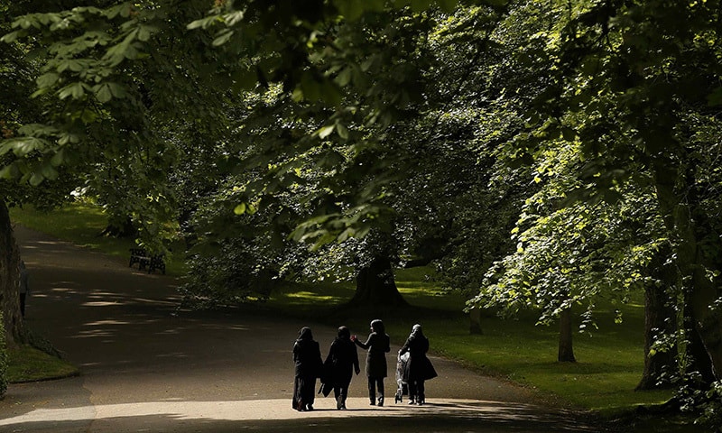 Muslim women walk through a park in Bradford, Britain, June 18, 2015. —Reuters