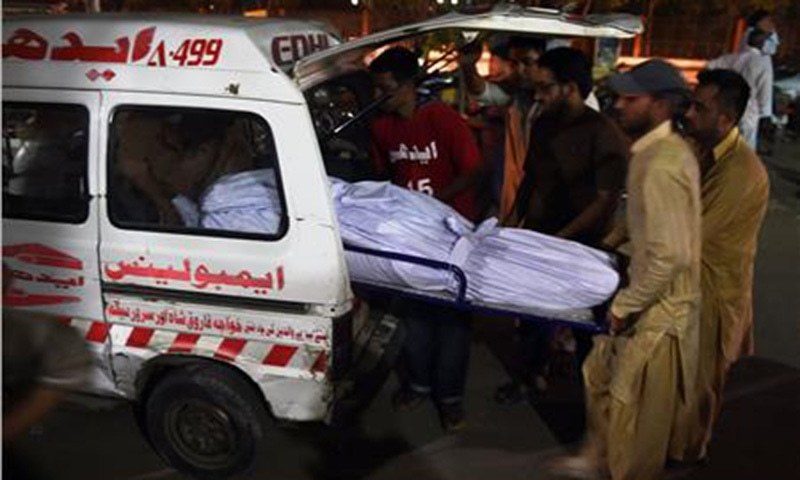 Edhi volunteers and relatives shift the body of a heatwave victim into an ambulance at the Edhi morgue.— AFP/File