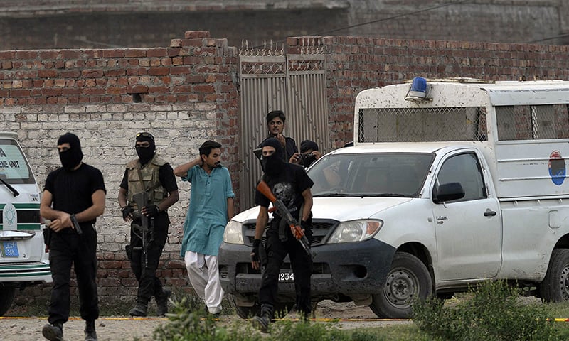 Pakistani police commandos cordon off the house following the raid. ─ AFP