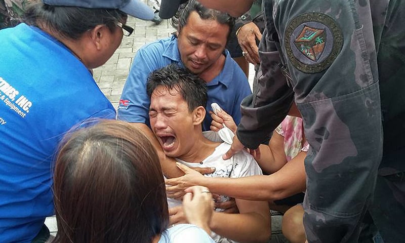 A survivor of a passenger ferry that capsized in rough waters cries after arriving at the pier in Ormoc City, central Philippines. ─ AFP