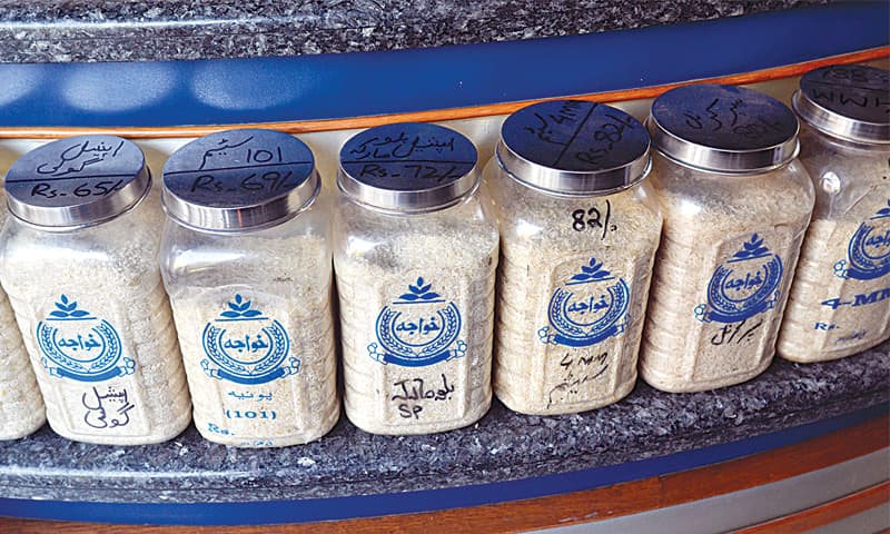 The different varieties of rice on display in jars at a shop.