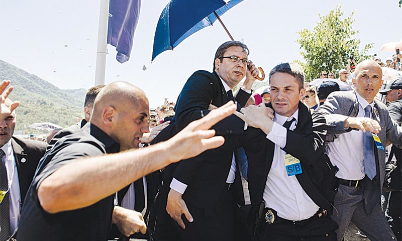 Srebrenica: Bodyguards try to protect Serbian Prime Minister Aleksandar Vucic from stones hurled at him by an angry crowd at the Potocari Memorial Centre, near this eastern Bosnian town. Tens of thousands of people gathered in Srebrenica on Saturday to commemorate the 20th anniversary of the massacre of thousands of Muslims in the worst mass killing in Europe since World War II. The Serbian leader was forced to leave the memorial when the crowd started to chant slogans and throw stones.—AFP