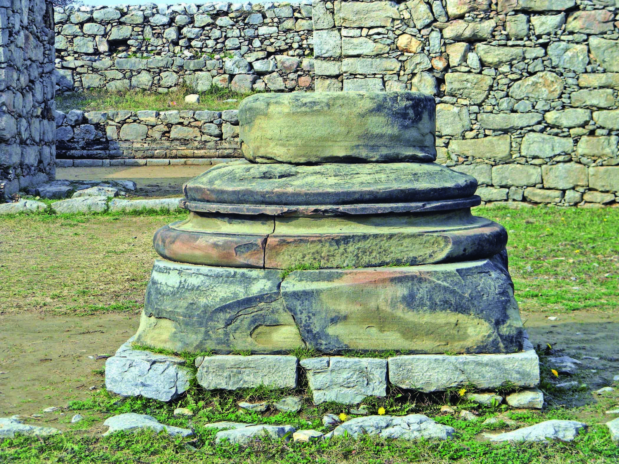 Base of the column of sandstone placed in front of Jandial temple.