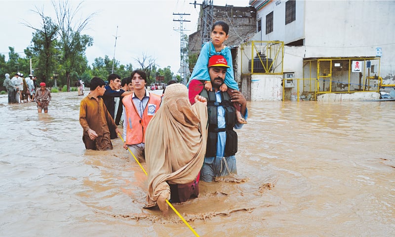 PESHAWAR: Rescue workers evacuate people stranded in floodwaters in Budhni Nullah on Charsadda Road.—Shahbaz Butt/White Star