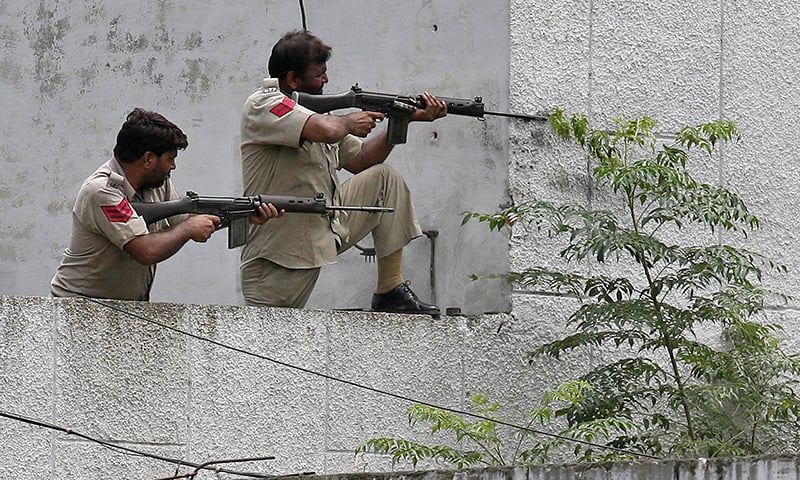 Policemen take their positions next to a police station during a gunfight at Dinanagar town in Gurdaspur district of Punjab, India. —Reuters