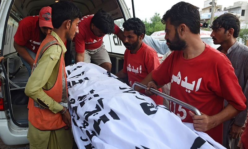 Pakistani volunteers shift the dead body of convicted murderer Shafqat Hussain to a mortuary after his execution in Karachi. -AFP