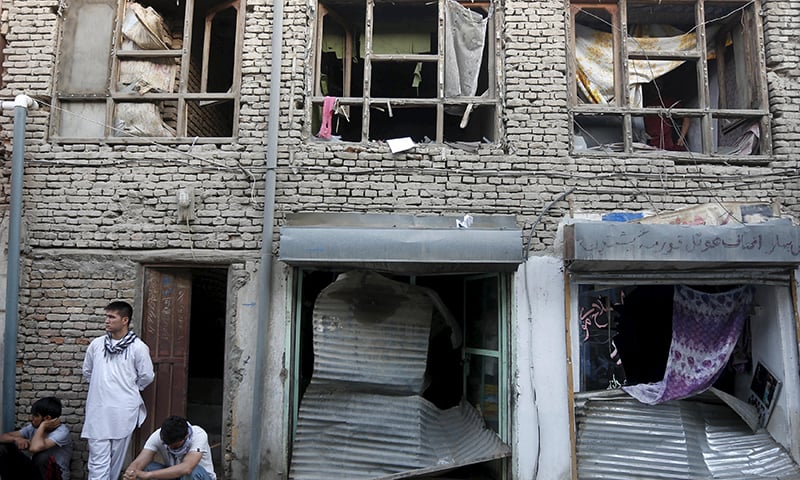 Afghan residents remove broken glass from their home and shops, caused by a suicide truck bomb attack. ─ Reuters