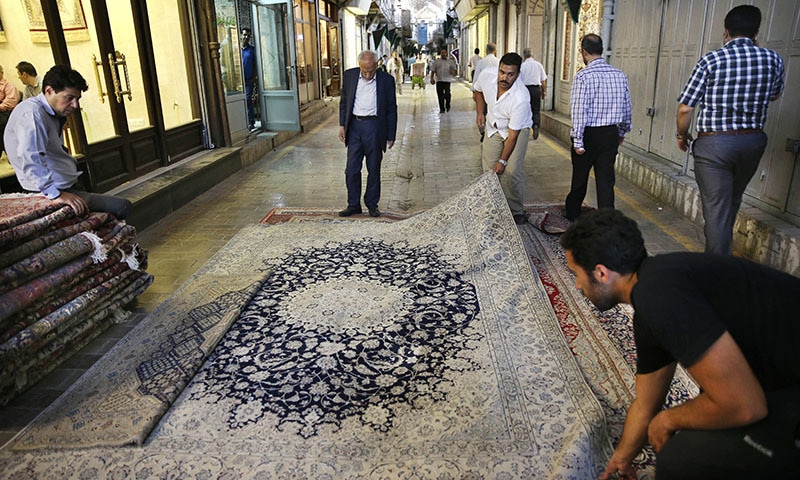 Iranian merchants display a carpet at the Tehran's old, main bazaar, Iran. - AP Photo/Vahid Salemi