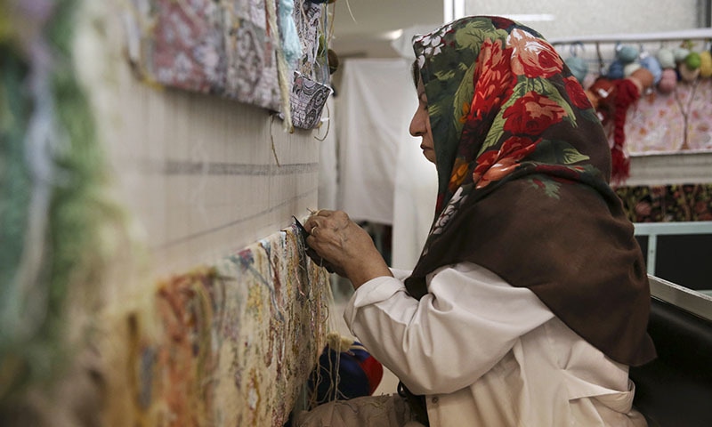 An Iranian woman weaves a carpet at a workshop of the Cultural and Artistic Carpet Foundation of Rassam Arabzadeh in Tehran, Iran. - AP Photo/Vahid Salemi