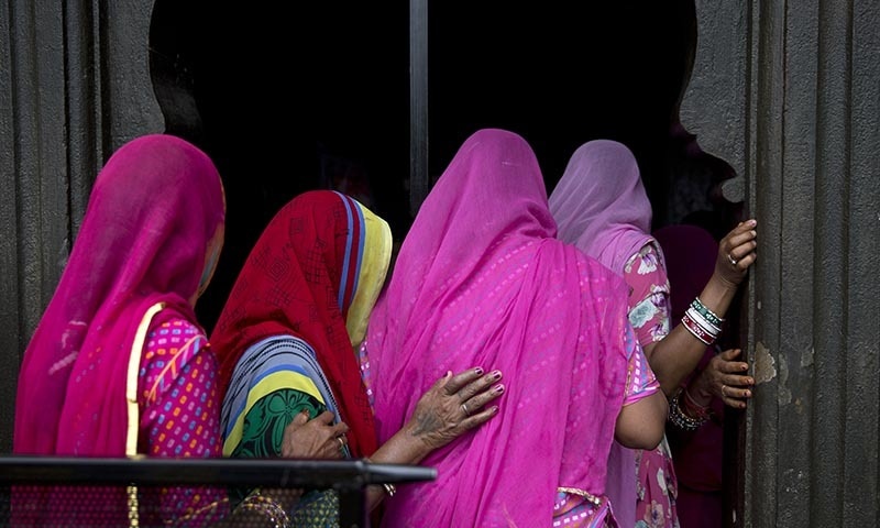 Indian women devotees stand in a queue as they wait to enter a temple near the Godavari River during the Kumbh Mela in Nashik, India. ─ AP