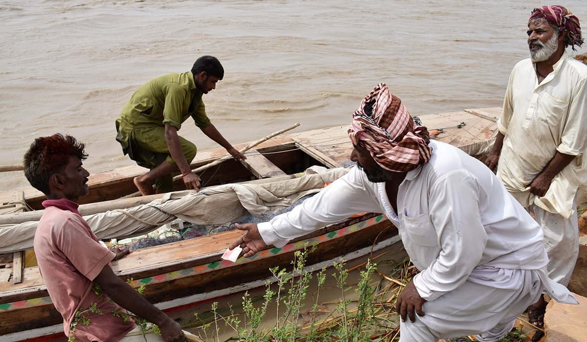 Fishermen prepare their boat for a trip down the river. -Photo by author