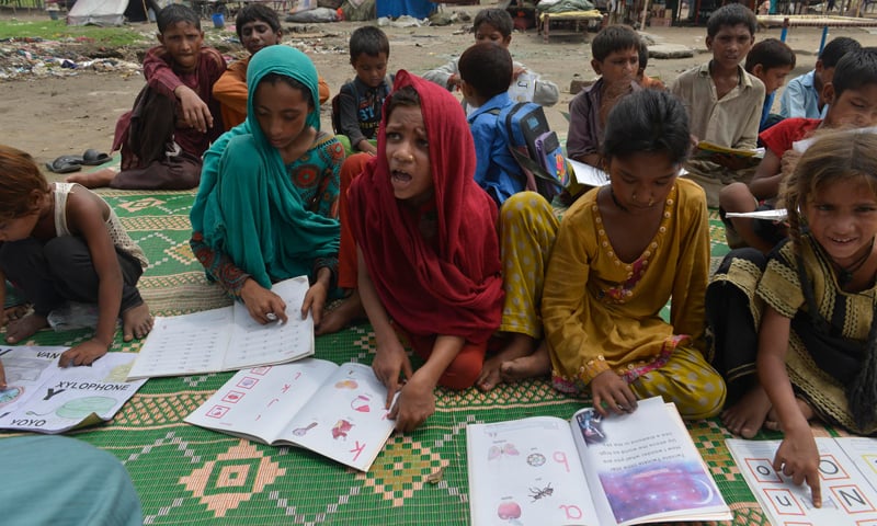 Children at a slum in Lahore attend class at a makeshift, open air school.—White Star