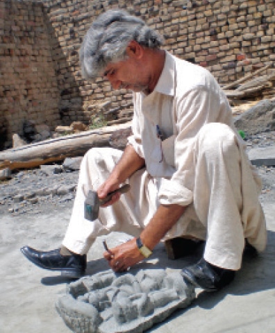 An artist carving stone at a workshop. &mdash; Dawn